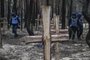 Ukrainian servicemen search for land mines at a burial site in a forest on the outskirts of Izyum, eastern Ukraine on September 16, 2022. - Ukraine said on September 16, 2022 it had counted 450 graves at just one burial site near Izyum after recapturing the eastern city from the Russians. (Photo by Juan BARRETO / AFP)<!-- NICAID(15207853) -->