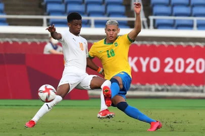 Ivory Coast's forward Amad Diallo (L) fights for the ball with Brazil's forward Richarlison (R) during the Tokyo 2020 Olympic Games men's group D first round football match between Brazil and Ivory Coast at the Yokohama International Stadium in Yokohama on July 25, 2021. (Photo by Yoshikazu TSUNO / AFP)<!-- NICAID(14844086) -->