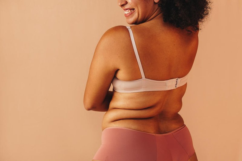 Back view of a happy curvy woman wearing underwear in a studioRearview of a happy curvy woman smiling cheerfully while wearing underwear in a studio. Body positive plus size woman feeling comfortable in her natural body.Indexador: Julia AmaralFonte: 605678278<!-- NICAID(15611686) -->