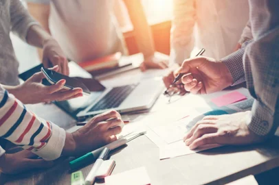 Team work process. Marketing strategy brainstorming. Paperwork and digital in open space. Intentional sun glareFonte: 112468033<!-- NICAID(15525117) -->