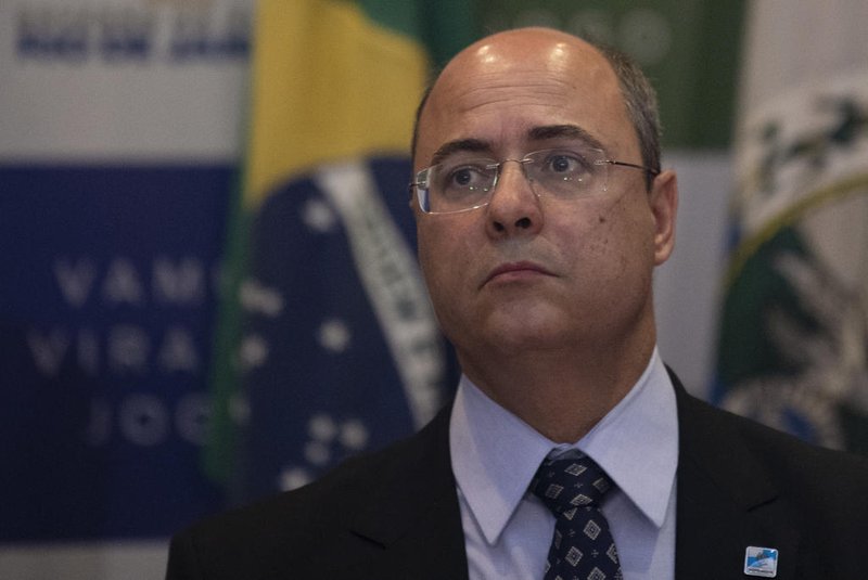 Rio de Janeiro's Governor Wilson Witzel (C) gestures during a press conference in Rio de Janeiro, Brazil, on September 23, 2019, after eight-year-old Agatha Sales Felix died during a police operation at the Alemao complex slum. - Felix was killed by a stray bullet during a confrontation between alleged drug traffickers and police officers on September 21. (Photo by MAURO PIMENTEL / AFP)<!-- NICAID(14260561) -->