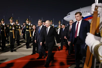 VLADIMIR SMIRNOV / POOL In this pool photograph distributed by the Russian state agency Sputnik, Russia's President Vladimir Putin is welcomed by Chinese Foreign Minister Wang Yi upon his arrival at Beijing Capital Airport in Beijing late on May 19, 2026. (Photo by Vladimir SMIRNOV / POOL / AFP)<!-- NICAID(16288903) -->