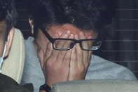 Tirada em 1º de novembro de 2021, mostra o suspeito Takahiro Shiraishi cobrindo o rosto com as mãos enquanto é transportado de uma delegacia de polícia em Tóquio para o Ministério Público<!-- NICAID(16068585) -->