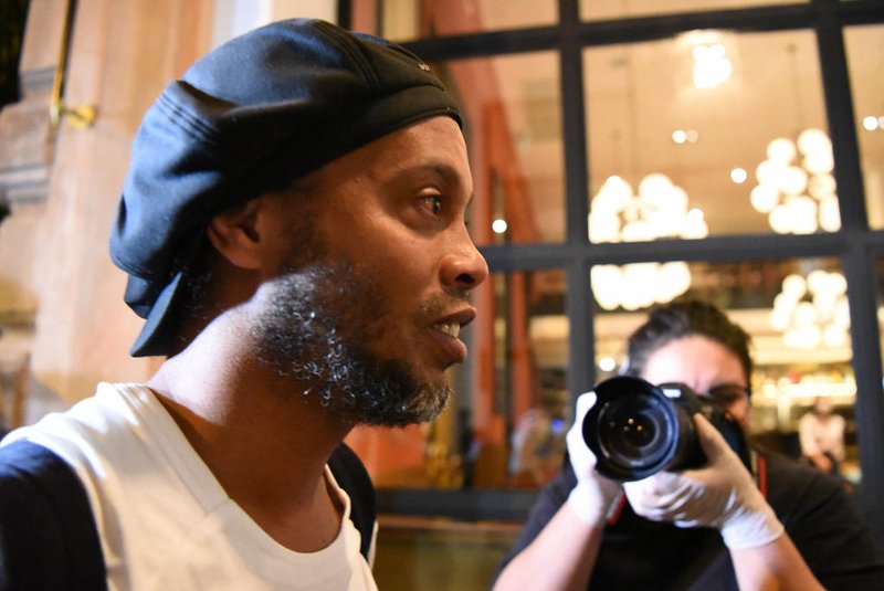 Brazilian retired football player Ronaldinho arrives at a hotel in Asuncion where he and his brother will serve house arrest after a judge ordered their release from jail on April 7, 2020. - A judge in Paraguay ordered the release of Ronaldinho and his brother Roberto Assis into house arrest after the siblings spent almost exactly a month in jail awaiting trial on charges of using false passports to enter Paraguay. Lawyers for the men posted bail of $1.6 million. (Photo by Norberto DUARTE / AFP)Editoria: CLJLocal: AsuncionIndexador: NORBERTO DUARTESecao: soccerFonte: AFPFotógrafo: STR<!-- NICAID(15254712) -->
