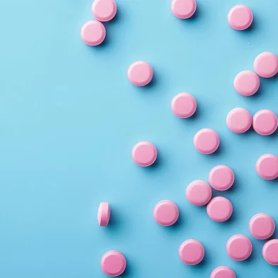 Blue background with pink pillsBlue background with pink pillsFonte: 812310458<!-- NICAID(15870505) -->