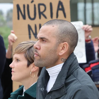 (FILES) Prison workers unions' members protest over the killing of a cook by an inmate the week before, as convicted rapist and former Brazil international football player Dani Alves (R), flanked by his lawyer Ines Guardiola, leaves Brians 2 prison in San Esteban Sasroviras, near Barcelona, on March 25, 2024. A Spanish appeals court overturned on March 28, 2025 former Brazil international footballer Dani Alves' rape conviction, arguing his trial was marked by "shortcomings" and "inaccuracies". Alves was sentenced to four-and-a-half years in jail in February last year for raping a young woman in the VIP bathroom of a Barcelona nightclub on December 31, 2022. (Photo by LLUIS GENE / AFP)<!-- NICAID(16008284) -->