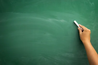Blank blackboard / chalkboard, hand writing on green chalk board holding chalk, great texture for textIndexador: photographer: Dusanka VisnjicanFonte: 68950001<!-- NICAID(16067790) -->