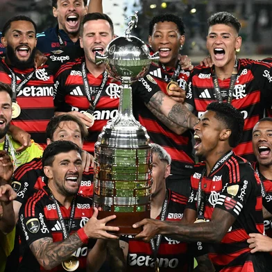 Flamengo's forward #27 Bruno Henrique (R) and Uruguayan midfielder #10 Giorgian de Arrascaeta (L) lift the the trophy with teammates after winning the all Brazilian Copa Libertadores final football match between Palmeiras and Flamengo at Monumental 'U' Marathon stadium in Lima on November 29, 2025. (Photo by Luis ACOSTA / AFP)Editoria: SPOLocal: LimaIndexador: LUIS ACOSTASecao: soccerFonte: AFPFotógrafo: STF<!-- NICAID(16177069) -->