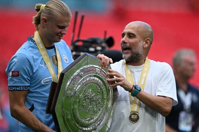 776187223Manchester City's Norwegian striker #09 Erling Haaland (L) jokes with Manchester City's Spanish manager Pep Guardiola as they hold the trophy after winning the English FA Community Shield football match between Manchester City and Manchester United at Wembley Stadium, in London on August 10, 2024. Manchester City  won after a 7-6 penalty shoot-out win, following the 1-1 draw in 90 minutes. (Photo by JUSTIN TALLIS / AFP) / NOT FOR MARKETING OR ADVERTISING USE / RESTRICTED TO EDITORIAL USEEditoria: SPOLocal: LondonIndexador: JUSTIN TALLISSecao: soccerFonte: AFPFotógrafo: STF<!-- NICAID(15844239) -->