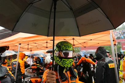 McLaren's British driver Lando Norris shelters from the rain under an umbrella on the grid before the start of the Formula One Belgian Grand Prix at the Spa-Francorchamps circuit in Spa, on July 27, 2025. (Photo by Dimitar DILKOFF / AFP)<!-- NICAID(16090764) -->