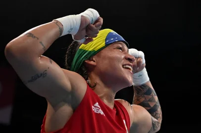 Brazil's Beatriz Ferreira (red) celebrates after winning against Uzbekistan's Raykhona Kodirova after their women's light (57-60kg) quarter-final boxing match during the Tokyo 2020 Olympic Games at the Kokugikan Arena in Tokyo on August 3, 2021. (Photo by Luis ROBAYO / POOL / AFP)<!-- NICAID(14854462) -->