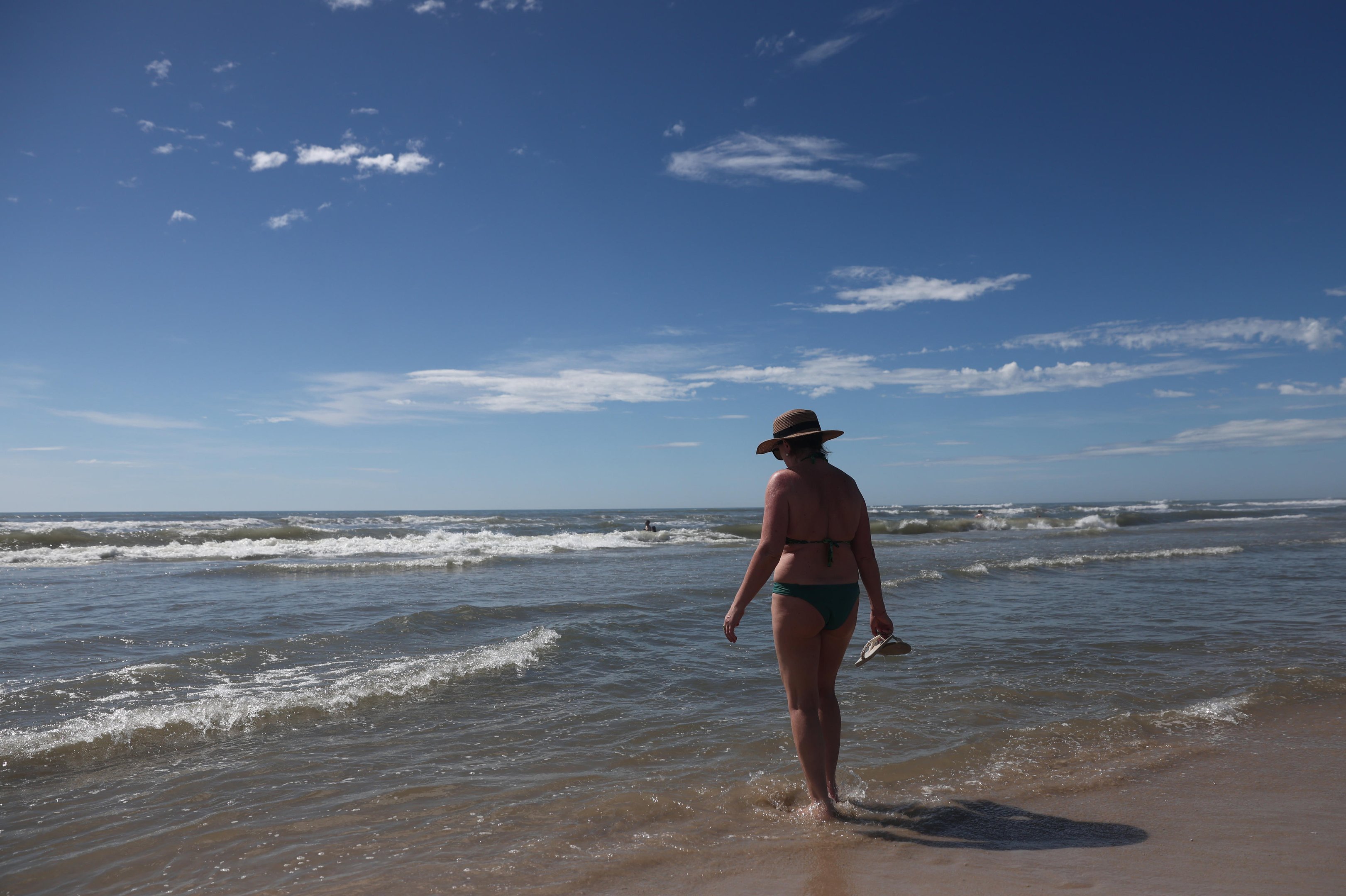 Apesar das nuvens, calor e mar claro atraem veranistas para a beira da praia em Cap&atilde;o da Canoa
