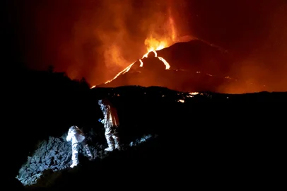 In this handout photograph taken and released by the Spanish Military Emergency Unit (UME) on October 16, 2021, members of the GIETMA (Technological and Environmental Emergencies Intervention Group) of the UME monitor the evolution of a new lava flow, following the eruption of the Cumbre Vieja volcano, on the Canary island of La Palma. - There is no prospect of the volcanic eruption in Spain's Canary Islands ending "in the short or medium term", experts said on October 13, 2021 after three-and-a-half weeks of activity. (Photo by Luismi Ortiz / UME / AFP) / RESTRICTED TO EDITORIAL USE - MANDATORY CREDIT "AFP PHOTO / LUISMI ORTIZ  / SPANISH MILITARY UNIT (UME) " - NO MARKETING - NO ADVERTISING CAMPAIGNS - DISTRIBUTED AS A SERVICE TO CLIENTS<!-- NICAID(14917415) -->
