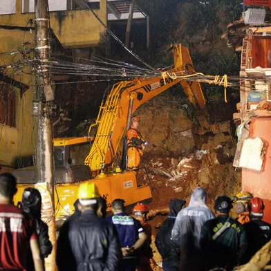 Rescue workers are seen at the site of a landslide in which a mother and six of her children were killed, in Paraty, Rio de Janeiro state, on April 2, 2022. - Torrential downpours triggered flash floods and landslides across Brazil's Rio de Janeiro state, killing at least 14 people including eight children, and leaving five missing, authorities said Saturday. (Photo by BRUNO KAIUCA / AFP)<!-- NICAID(15064723) -->
