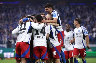 Hamburg's German forward #27 Davie Selke (hidden) celebrates scoring the 4-1 goal with his teammates during the German second division Bundesliga football match between Hamburg SV and SSV Ulm 1846 in Hamburg, northern  on May 10, 2025. Hamburg SV will return to play in the first division next season. (Photo by Ronny HARTMANN / AFP) / DFL REGULATIONS PROHIBIT ANY USE OF PHOTOGRAPHS AS IMAGE SEQUENCES AND/OR QUASI-VIDEOEditoria: SPOLocal: HamburgIndexador: RONNY HARTMANNSecao: soccerFonte: AFPFotógrafo: STR<!-- NICAID(16052944) -->