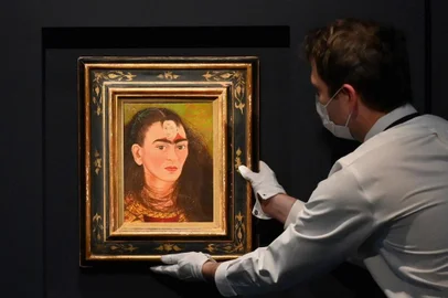 An art handler adjusts Frida Kahlo's final "Bust" Self-Portrait 'Diego y yo" (Diego and I) at Sotheby's on November 5, 2021 in New York City. - After more than a year, in-person auctions are returning to New York this week with the sale of the exceptional Macklowe collection, reputed to be the most expensive in the world to come onto the market -- and buyers are champing at the bit after the pandemic.At renowned auction houses Christie's and Sotheby's, the message is the same: the art market is doing very well.With fall sales estimated to bring in more than $1 billion in a week, starting on November 15, "this is our largest sale season that we've presented since 2015," a record year, said Brooke Lampley, president of the fine arts department at Sotheby's. (Photo by ANGELA WEISS / AFP) / RESTRICTED TO EDITORIAL USE - MANDATORY MENTION OF THE ARTIST UPON PUBLICATION - TO ILLUSTRATE THE EVENT AS SPECIFIED IN THE CAPTION<!-- NICAID(14942887) -->