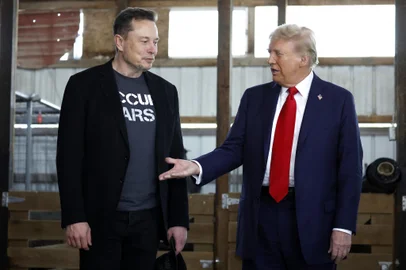 O presidente eleito dos EUA, Donald Trump, estende a mão para o bilionário Elon Musk.<!-- NICAID(15912768) -->