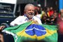Brazilian former President (2003-2010) and candidate for the leftist Workers Party (PT) Luiz Inacio Lula da Silva holds a Brazilian flag while leaving a polling station during the presidential run-off election, in Sao Paulo, Brazil, on October 30, 2022. - After a bitterly divisive campaign and inconclusive first-round vote, Brazil elects its next president in a cliffhanger runoff between far-right incumbent Jair Bolsonaro and veteran leftist Luiz Inacio Lula da Silva. (Photo by CARL DE SOUZA / AFP)<!-- NICAID(15250258) -->