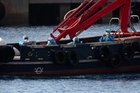 People wearing blue protective suits are evacuated on a boat from the Dutch flagged hantavirus-stricken cruise ship MV Hondius at the industrial port of Granadilla de Abona on the island of Tenerife in Spain's Canary Islands on May 10, 2026. Repatriation flights for the nearly 150 passengers onboard the ship hit by a deadly hantavirus outbreak are planned to the United States, Britain, France,  and other countries, Spain's interior minister announced on Saturday. Most of the nearly 150 people on board will be transferred to shore on smaller vessels then by bus to the airport and then flown home after weeks at sea. (Photo by JORGE GUERRERO / AFP)<!-- NICAID(16282084) -->