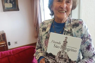 Suzana Postali Fantinel, autora do livro de memórias Vivendo São Pelegrino, sobre as histórias e persnagens do bairro onde nasceu e vive até hoje. Ao fundo, no quadro, os pais Guilhermina Andreazza Postali e Aparício Postali, em uma fotopintura do Studio Geremia.Livro tem lançamento neste sábado, na Feira do Livro de Caxias do Sul.<!-- NICAID(15886653) -->