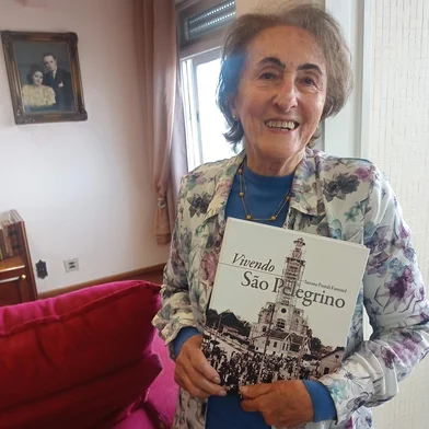 Suzana Postali Fantinel, autora do livro de memórias Vivendo São Pelegrino, sobre as histórias e persnagens do bairro onde nasceu e vive até hoje. Ao fundo, no quadro, os pais Guilhermina Andreazza Postali e Aparício Postali, em uma fotopintura do Studio Geremia.Livro tem lançamento neste sábado, na Feira do Livro de Caxias do Sul.<!-- NICAID(15886653) -->