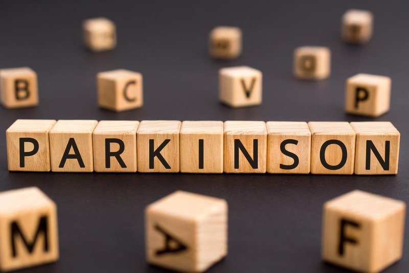 Parkinson - word from wooden blocks with letters, parkinson disease of the nervous system concept, random letters around black backgroundFonte: 335765992<!-- NICAID(15730652) -->