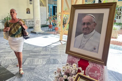 A woman walks past a portrait of the late Pope Francis at the Archbishopric in Havana on April 21, 2025. Pope Francis died on April 21, 2025, aged 88, a day after making a much hoped-for appearance at Saint Peter's Square on Easter Sunday, the Vatican said in a statement. (Photo by YAMIL LAGE / AFP)Editoria: RELLocal: HavanaIndexador: YAMIL LAGESecao: roman catholicFonte: AFPFotógrafo: STF<!-- NICAID(16021180) -->