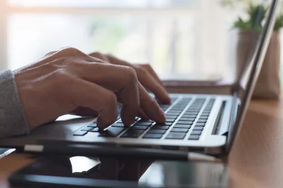Young man or freelancer using laptop computer, searching web with morning light, browsing internet information, working from home office concept, close upFonte: 280005774<!-- NICAID(14919110) -->