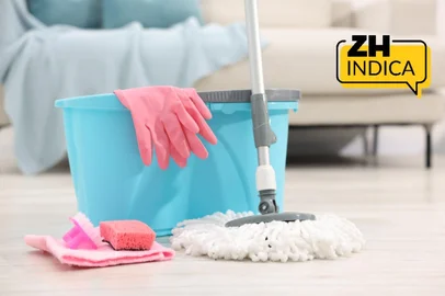 String mop and bucket with cleaning supplies on wooden floor indoors<!-- NICAID(16272110) -->