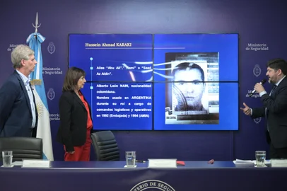 Argentina's Security Minister Patricia Bullrich (C) and Argentina's Intelligence State Secretary (SIDE) director Sergio Neiffert (L) listen to the National Director of Criminal Intelligence Ricardo Picado while he addresses the press in front of a screen displaying the photo of Hussein Ahmad Karaki, accused of being the head of Hezbollah in South America and planner of the attacks of Israel's Embassy in 1992 and the Jewish mutual AMIA in 1994, and for whom they requested an arrest warrant from Interpol, in Buenos Aires on October 25, 2024. According to a report by the Argentine intelligence, Karaki had been in Buenos Aires on the day of the attack on the Embassy, on March 17, 1992, and had left the country using a Colombian passport hours before the explosion. (Photo by JUAN MABROMATA / AFP)<!-- NICAID(15899732) -->