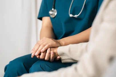 A female nurse caregiver holds hands to encourage and comfort an elderly woman. For care and trust in nursing homes for people of retirement age Caregiver helping elderly woman provides medical adviceFonte: 752092287<!-- NICAID(15774876) -->