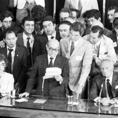 Tancredo Neves.Em 15 de janeiro de 1985, em eleição indireta realizada através do Colégio Eleitoral, os candidatos da Aliança Democrática (coligação formada pelos partidos de oposição, com exceção do PT, liderados pelo PMDB, e a Frente Liberal, integrada pelos dissidentes do PDS), Tancredo Neves e José Sarney (derrotando Maluf por 480 votos contra 180), foram eleitos, respectivamente, presidente e vice-presidente da República, pondo fim ao ciclo de presidentes militares impostos pelo regime instaurado pelo movimento político-militar de 31 de março de 1964. Tinha início, assim, uma nova era na história política do Brasil, denominada por Tancredo Neves de Nova República. No centro da foto está o deputado Ulisses Guimarães.#envelope: 28815<!-- NICAID(11345042) -->