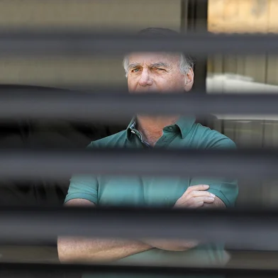 Former Brazilian President Jair Bolsonaro stands at the garage of his residence in Brasilia on September 11, 2025. A Brazilian judge on September 10 returned the first not-guilty vote in the coup-plotting trial of former president Jair Bolsonaro, shifting all eyes on the last two of his colleagues left to vote following two guilty findings. The 70-year-old far-right ex-leader risks a prison sentence of more than 40 years if found guilty of seeking to claw back power after his defeat in 2022 elections to leftist Luiz Inacio Lula da Silva (Photo by Sergio Lima / AFP)<!-- NICAID(16122040) -->