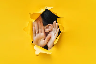 Female ear and hands close-up. Copy space. Torn paper, yellow background. The concept of eavesdropping, espionage, gossip and the yellow press.Female ear and hands close-up. Copy space. Torn paper, yellow background. The concept of eavesdropping, espionage, gossip and the yellow press. Foto: shchus  / stock.adobe.comFonte: 285286400<!-- NICAID(16078412) -->