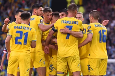 Ukraine's midfielder Andriy Yarmolenko is mobbed by teammates after scoring the opening goal during the FIFA World Cup 2022 play-off semi-final qualifier football match between Scotland and Ukraine at Hampden Park in Glasgow, Scotland on June 1, 2022. (Photo by ANDY BUCHANAN / AFP)<!-- NICAID(15112486) -->