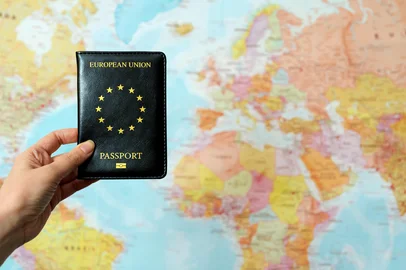 European Union passport in front of world map.<!-- NICAID(16231143) -->