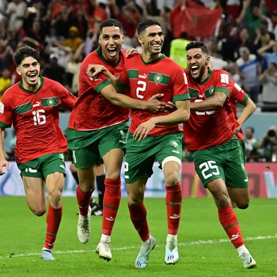 Morocco's defender #02 Achraf Hakimi (C) celebrates with teammates after converting the last penalty during the penalty shoot-out to win the Qatar 2022 World Cup round of 16 football match between Morocco and Spain at the Education City Stadium in Al-Rayyan, west of Doha on December 6, 2022. (Photo by JAVIER SORIANO / AFP)<!-- NICAID(15287223) -->