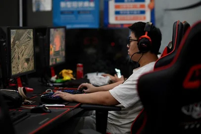A man plays an online game at a computer shop in Beijing on August 31, 2021, a day after China announced a drastic cut to children's online gaming time to just three hours a week in the latest move in a broad crackdown on tech giants. (Photo by Noel Celis / AFP)<!-- NICAID(14885008) -->
