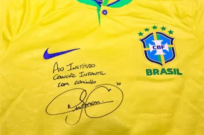 Já está disponível uma super oportunidade para torcer pela Seleção Brasileira e contribuir com o Instituto do Câncer Infantil. Um dos itens que disponíveis no Leilão da Coragem, promovido em parceria com a Pestana Leilões, é a camisa amarelinha autografada pelo craque Neymar. Com lance inicial de R$2 mil reais, os interessados já podem acessar o site para os primeiros lances.Além da camisa de Neymar, estão disponíveis camisas da dupla grenal e de outros clubes. O leilão ainda terá itens como joias, instrumentos musicais, vestidos de festa e obras de arte para lances.O Leilão da Coragem encerra no dia 7 de dezembro, na sede da Pestana Leilões. O leilão também acontecerá de forma on-line para quem se interessar.<!-- NICAID(15272665) -->