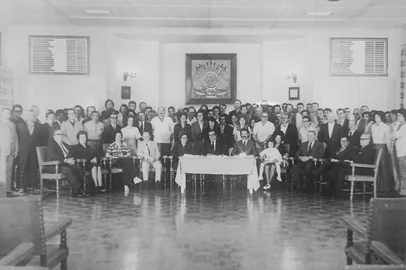 Depois das visitas guiadas realizadas em dezembro, integrando a programação do Natal de Afetos, e outras três durante a Festa Nacional da Uva, o Pátio Eberle incluiu os passeios pela história do prédio em sua programação mensal. Sob a orientação deste colunista, haverá visitas guiadas ao terraço e outros pontos históricos do edifício sempre no primeiro sábado de cada mês. Os participantes poderão conhecer mais sobre a história e as curiosidades de símbolos arquitetônicos do centro de Caxias, como a casinha de madeira, relógio e a famosa “piteira”, situada em dois pontos do telhado. Legenda: o jubileu de prata dos senhores Glacyr Moré (sentado ao centro), José Panosso e Odilon Canani. Glacyr iniciou na fábrica em 1º de janeiro de 1948. É dessa solenidade a foto oficial ao lado, mantida pela família. Glacyr (ao centro) aparece junto da família, direção da empresa e outros dois colegas jubilados: os senhores José Panosso e Odilon Canani. O local? O Salão Nobre da metalúrgica, no último andar do prédio, atual sede do Instituto de Leitura Quindim. O local é um dos espaços que integram o passeio guiado deste sábado.<!-- NICAID(15722035) -->