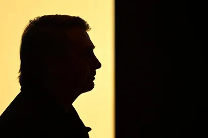 Silhouette of former Brazilian President Jair Bolsonaro taken during the first edition of the Liberal Party's Communication Seminar in Brasilia on February 20, 2025. Brazil's far-right former president Jair Bolsonaro on February 19 said he was the victim of an "authoritarian regime" concocting accusations against him, after he was charged with orchestrating a coup bid. Bolsonaro, 69, now faces a possible high-profile trial ahead of 2026 elections, in which he hopes to make a triumphant comeback, much like his hero and ally US President Donald Trump. (Photo by EVARISTO SA / AFP)Editoria: POLLocal: BrasíliaIndexador: EVARISTO SASecao: parties and movementsFonte: AFPFotógrafo: STF<!-- NICAID(15980782) -->