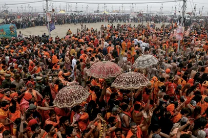 EDITORS NOTE: Graphic content / Naga Sadhus or Hindu holy men arrive to take a dip in Sangam, the confluence of Ganges, Yamuna and mythical Saraswati rivers, for Shahi Snan or 'royal bath', during the Maha Kumbh Mela festival, in Prayagraj on January 14, 2025. Vast crowds of Hindu pilgrims in India bathed in sacred waters as the Kumbh Mela festival opened on January 13, with organisers expecting 400 million people -- the world's largest gathering of humanity -- to assemble over six weeks. (Photo by Niharika KULKARNI / AFP)Editoria: RELLocal: PrayagrajIndexador: NIHARIKA KULKARNISecao: hinduismFonte: AFPFotógrafo: STR<!-- NICAID(15953156) -->