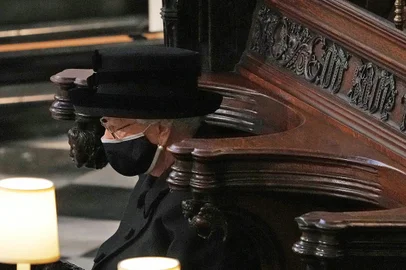 Britain's Queen Elizabeth II sits alone in the quire of St George's Chapel during the funeral service of her husband Britain's Prince Philip, Duke of Edinburgh in Windsor Castle in Windsor, west of London, on April 17, 2021. - Philip, who was married to Queen Elizabeth II for 73 years, died on April 9 aged 99 just weeks after a month-long stay in hospital for treatment to a heart condition and an infection. (Photo by Yui Mok / POOL / AFP)<!-- NICAID(14760570) -->
