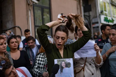 Nasibe Samsaei, an Iranian woman living in Turkey, cuts her ponytail off during a protest outside the Iranian consulate in Istanbul on September 21, 2022, following the death of an Iranian woman after her arrest by the country's morality police in Tehran. - Mahsa Amini, 22, was on a visit with her family to the Iranian capital Tehran, when she was detained on September 13, 2022, by the police unit responsible for enforcing Iran's strict dress code for women, including the wearing of the headscarf in public. She was declared dead on September 16, 2022 by state television after having spent three days in a coma. (Photo by Yasin AKGUL / AFP)<!-- NICAID(15215147) -->