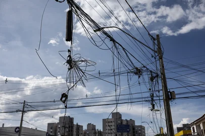 PORTO ALEGRE, RS, BRASIL, 07-01-2026: EMARANHADOS DE FIOS  E BURACOS NAS CALÇADAS. Na rua Adda Mascarenhas de Moraes, zona norte de Porto Alegre, moradores e lojsitas locais reclamam das más condições das calçadas, buracos em vias, e emaranhados de fios de luz e internet que deixam as ruas com condições precárias. Fotos: Duda Fortes/Agencia RBS<!-- NICAID(16199630) -->