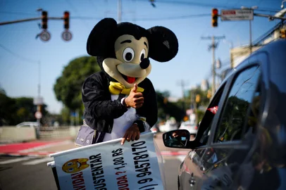 PORTO ALEGRE, RS, BRASIL - 2022.07.18 - Raí Brum se veste de Mickey nas sinaleiras de Porto Alegre para vender pipoca. Com a mulher grávida de 3 meses, Raí leva um cartaz pedindo ajuda dizendo que Minnie está grávida. (Foto: ANDRÉ ÁVILA/ Agência RBS)<!-- NICAID(15151929) -->