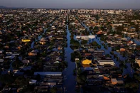 As piores enchentes do BrasilInundações recordes no estado do Rio Grande do Sul, Brasil, causaram devastação ambiental, o deslocamento de mais de 600.000 moradores e a morte de 183 pessoas. O governo declarou que foi o maior desastre climático do estado, com 2,39 milhões de moradores afetados e grandes perdas humanas, não humanas e econômicas. De acordo com uma equipe de cientistas internacionais, as mudanças climáticas, intensificadas pelo El Niño, tornaram as inundações duas vezes mais prováveis. Especialistas alertam que esses eventos climáticos extremamente raros, antes esperados para ocorrer a cada 100 a 250 anos, se tornarão mais frequentes devido à queima de combustíveis fósseis e outras formas de degradação ambiental. As inundações devastaram as economias e comunidades locais. Enquanto alguns moradores estão saindo para começar de novo, outros estão escolhendo ficar e reconstruir suas vidas. <!-- NICAID(16005375) -->