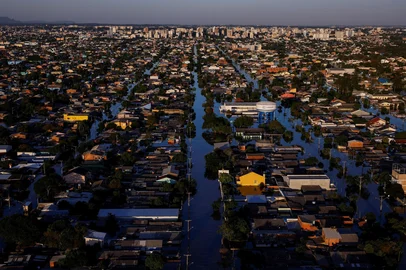 As piores enchentes do BrasilInundações recordes no estado do Rio Grande do Sul, Brasil, causaram devastação ambiental, o deslocamento de mais de 600.000 moradores e a morte de 183 pessoas. O governo declarou que foi o maior desastre climático do estado, com 2,39 milhões de moradores afetados e grandes perdas humanas, não humanas e econômicas. De acordo com uma equipe de cientistas internacionais, as mudanças climáticas, intensificadas pelo El Niño, tornaram as inundações duas vezes mais prováveis. Especialistas alertam que esses eventos climáticos extremamente raros, antes esperados para ocorrer a cada 100 a 250 anos, se tornarão mais frequentes devido à queima de combustíveis fósseis e outras formas de degradação ambiental. As inundações devastaram as economias e comunidades locais. Enquanto alguns moradores estão saindo para começar de novo, outros estão escolhendo ficar e reconstruir suas vidas. <!-- NICAID(16005375) -->