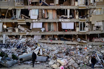 A man walks among the rubble of a collapsed building in Hatay, on February 10, 2023, four days after the 7.8 magnitude earthquake that killed over 11.200 people. - Searchers were still pulling survivors on February 8 from the rubble of the earthquake that killed over 11,200 people in Turkey and Syria, even as the window for rescues narrowed. For two days and nights since the 7.8 magnitude quake, thousands of searchers have worked in freezing temperatures to find those still alive under flattened buildings on either side of the border. (Photo by Yasin AKGUL / AFP)Editoria: DISLocal: HatayIndexador: YASIN AKGULSecao: earthquakeFonte: AFPFotógrafo: STR<!-- NICAID(15345862) -->