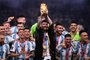 Argentina's captain and forward #10 Lionel Messi (C) lifts the FIFA World Cup Trophy on stage as he celebrates with teammates after they won the Qatar 2022 World Cup final football match between Argentina and France at Lusail Stadium in Lusail, north of Doha on December 18, 2022. (Photo by Kirill KUDRYAVTSEV / AFP)Editoria: SPOLocal: DohaIndexador: KIRILL KUDRYAVTSEVSecao: soccerFonte: AFPFotógrafo: STF<!-- NICAID(15298756) -->